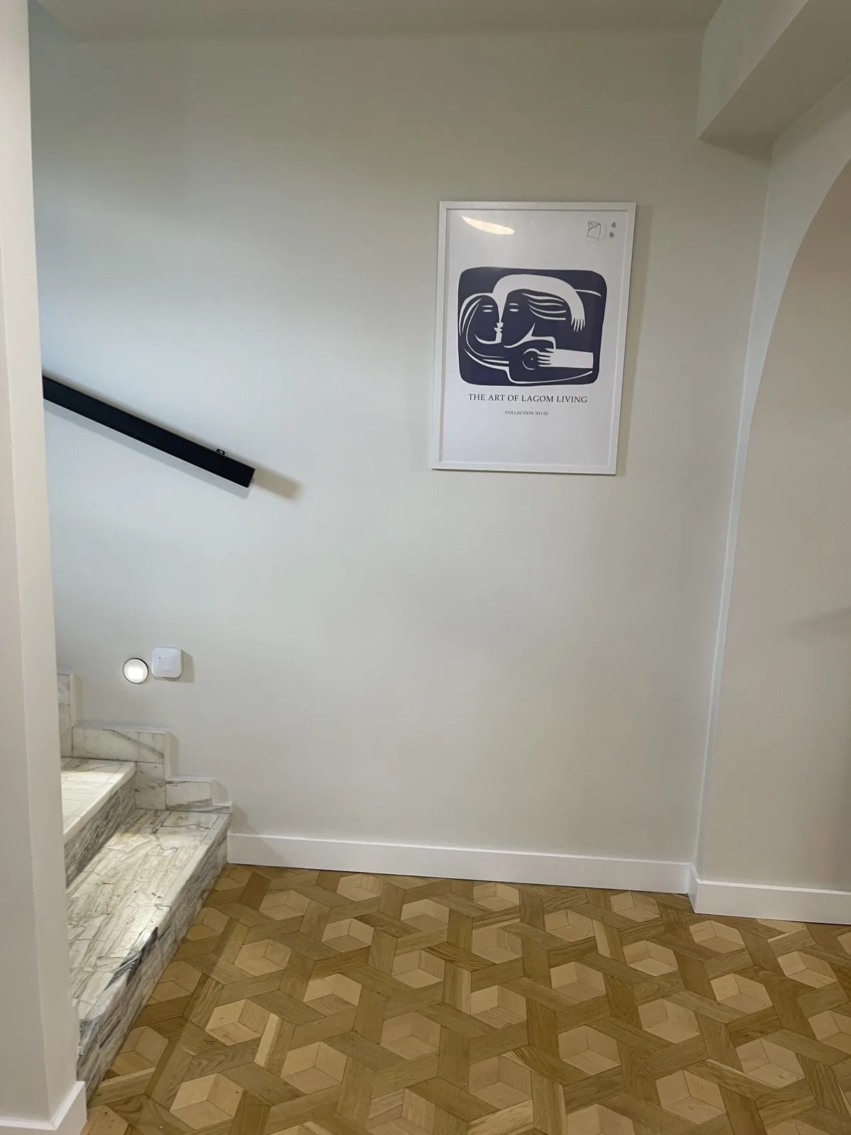 Hol F6 Campus z plakatem The Art of Lagom Living i geometrycznym parkietem